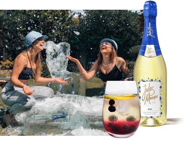 Zwei Frauen in einem Garten haben Spaß mit Eis und Sekt, ihre Freude und die sommerliche Stimmung sind deutlich spürbar.