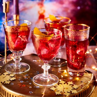 Ein festlicher Tisch mit glitzernden Getränken, die in eleganten Gläsern serviert werden, umgeben von funkelnden Dekorationen.