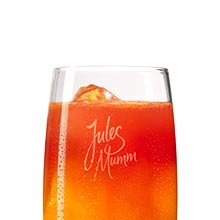 Ein stilvolles Glas mit einem fruchtigen Cocktail, das mit Eis gefüllt ist und die Aufschrift 'Jules Mumm' trägt.