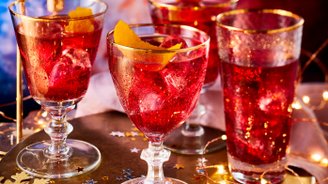 Ein festlicher Tisch mit glitzernden Getränken, die in eleganten Gläsern serviert werden, umgeben von funkelnden Dekorationen.
